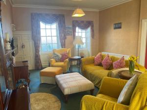 a living room with a yellow couch and chairs at Dufferin Coaching Inn in Killyleagh