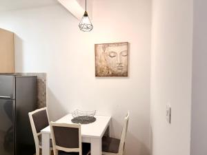 a dining room with a table and a picture of a head at Odmor u Podgorici. in Podgorica