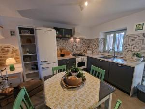 a kitchen with a table and a kitchen with a refrigerator at Hiža Bepina in Marčana