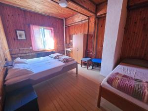 a bedroom with two beds in a wooden cabin at Great Mountain B&B Platak in Platak