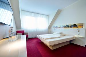 a bedroom with a white bed and a red carpet at Hotel-Restaurant Öhlers in Hannover