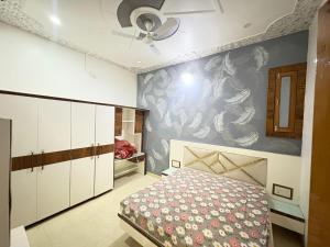 a bedroom with a bed and a ceiling fan at Karshni Kuteer in Mathura