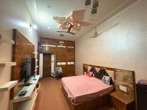 a room with a bed and a tv in it at Karshni Kuteer in Mathura