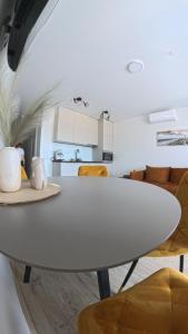 a white table in a kitchen with yellow chairs at Harmony Shore Apartments in Palanga