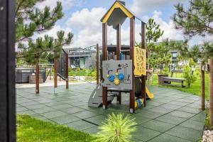 a playground with a slide in a park at Harmony Shore Apartments in Palanga