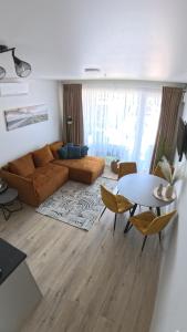 a living room with a couch and a table at Harmony Shore Apartments in Palanga