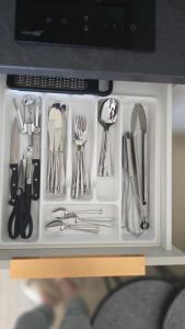 a drawer full of utensils sitting on a table at Harmony Shore Apartments in Palanga +5 photos