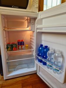 an open refrigerator with bottles of water and milk at Quiet Tortellini in Modena