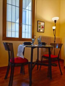 a dining room table with two chairs and a table with a lamp at Quiet Tortellini in Modena