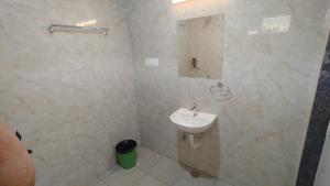 a white bathroom with a sink and a mirror at COMFORT Inn in Subrahmanya
