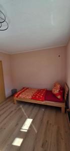 a bedroom with a bed in a room with wooden floors at Ferienwohnung Baumgartner in Aigen im Ennstal
