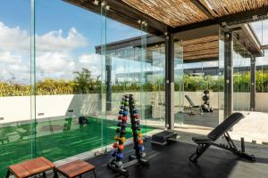 an indoor gym with a pool in a house at Bloom Tulum, Apartments by Marriott Bonvoy in Tulum