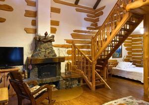 a living room with a fireplace and a staircase at Lisotel in Rokytne