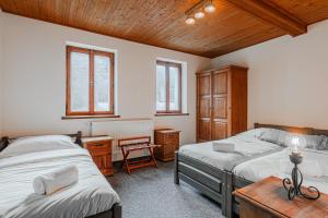 a bedroom with two beds and a wooden ceiling at Villa Pontis Rabštejn nad Střelou in Rabštejn nad Střelou
