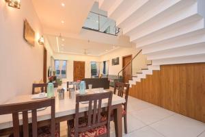 a dining room with a table and chairs at 6BHK White Castle Villa in Malavli