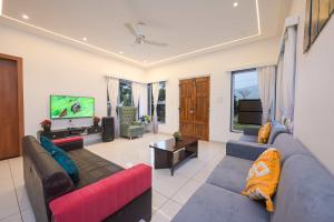a living room with two couches and a tv at 6BHK White Castle Villa in Malavli