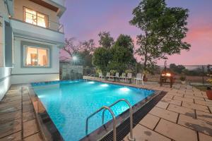 a swimming pool in the backyard of a house at 6BHK White Castle Villa in Malavli