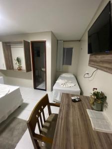 a small living room with a table and a television at Hotel Pedra da Letra in Mauriti