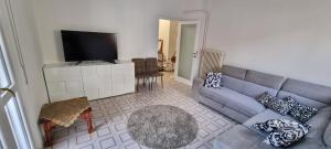 a living room with a blue couch and a flat screen tv at Melis Apartment in Como