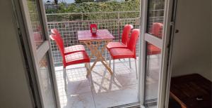 a table and chairs on a balcony with a glass door at Melis Apartment in Como