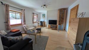 a living room with a couch and a tv at Schöne helle Ferienwohnung in Eurasburg