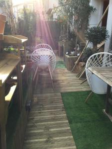 a patio with a table and chairs on a wooden floor at Maison Parnasse in Castelnau-de-Guers