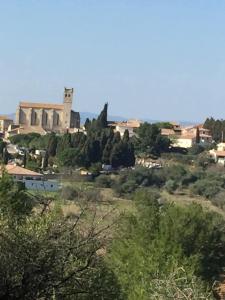 a view of a town with a building on a hill at Maison Parnasse in Castelnau-de-Guers