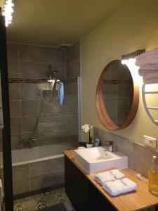 a bathroom with a sink and a tub and a mirror at Maison Parnasse in Castelnau-de-Guers