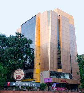 a large glass building with a sign on it at Privilege Inn in Mumbai