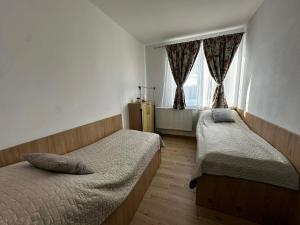 a bedroom with two beds and a window at Apartmány Silvia in Dunajská Streda +108 photos
