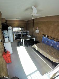 a living room with a couch and a kitchen at Morada das Flores in Palhoça