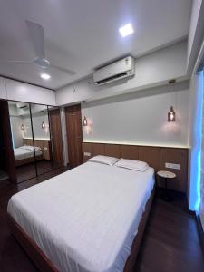 a bedroom with a large white bed and a mirror at Skyline Serenia 23rd floor in Dehu Road +27 photos