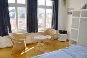 a bedroom with chairs and a table and a bed at Appartementhaus Seestern in Borkum