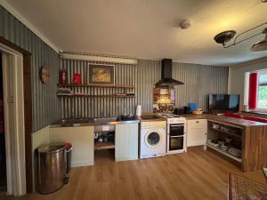 a kitchen with a stove and a washing machine at Hay View Lodges - Barn End in Hay-on-Wye +7 photos