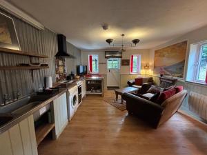 a living room with a couch and a kitchen at Hay View Lodges - Barn End in Hay-on-Wye
