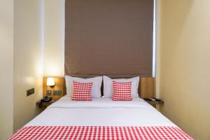 a bedroom with a bed with red and white pillows at Open Hotel by Olive - Urban Suites in Bangalore