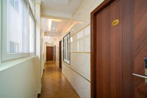 a hallway with a wooden door and a window at Open Hotel by Olive - Urban Suites in Bangalore