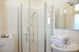 a bathroom with a shower and a sink and a mirror at Appartementhaus Seestern in Borkum +145 photos