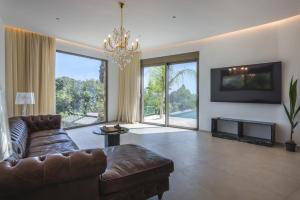 a living room with a couch and a chandelier at Orama Estate in Koskinou