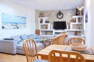 a living room with a couch and a table and chairs at Appartementhaus Seestern in Borkum