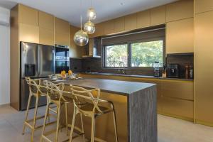 a kitchen with a large island with bar stools at Orama Estate in Koskinou