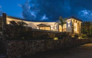 a house with a stone wall at night at Orama Estate in Koskinou