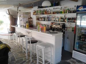 a bar with stools in a room with a counter at Maistrali Studios Skiathos in Koukounaries