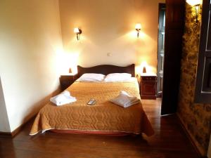 a bedroom with a bed with two towels on it at Ξενώνας Αρχοντικό Πρεδάρη in Goura