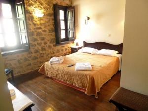 a bedroom with a bed with two towels on it at Ξενώνας Αρχοντικό Πρεδάρη in Goura