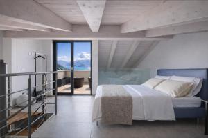 a bedroom with a large bed and a balcony at Splend'Or - A Real Paradise in Perledo