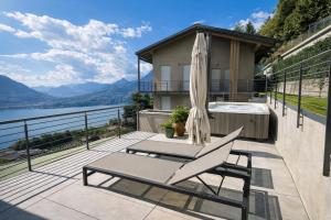 a patio with a chair and a umbrella and a tub at Splend'Or - A Real Paradise in Perledo