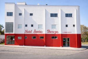 a red and white building with the words hotel santos therapy at Hotel Santa Thereza in Bofete