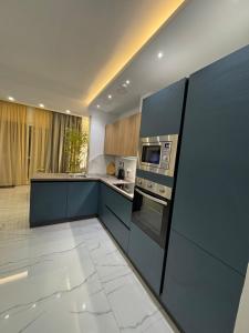 a kitchen with blue cabinets and a stove top oven at B&S Accommodation Newly Renovated Penthouse 253 in Żejtun