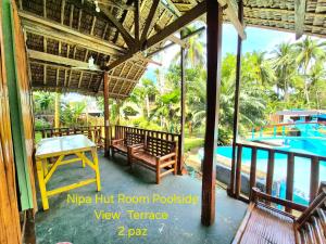 Ein Pavillon mit Tisch und Bänken neben einem Pool in der Unterkunft Concepcion Resort in Inopacan